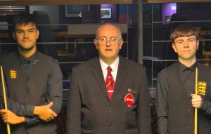 Paul Deaville and Oliver Sykes are in their waistcoats and holding their cues standing either side of referee Andy Kitson before the final.