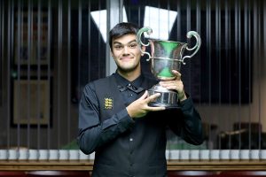 Paul Deaville smiles and lifts the English Amateur Snooker Championship trophy.