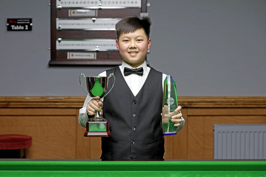 Shaun Liu holds the English Under-14 Snooker Championship trophy.