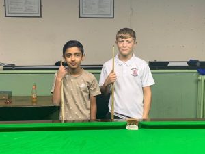 Faiz Majid and Oscar Newton stand next to each other with cues by a snooker table.