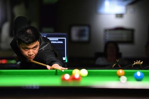 Manasawin Phetmalaikul plays a shot at the table.