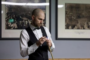 Steven Hallworth chalks his cue and looks at the table.